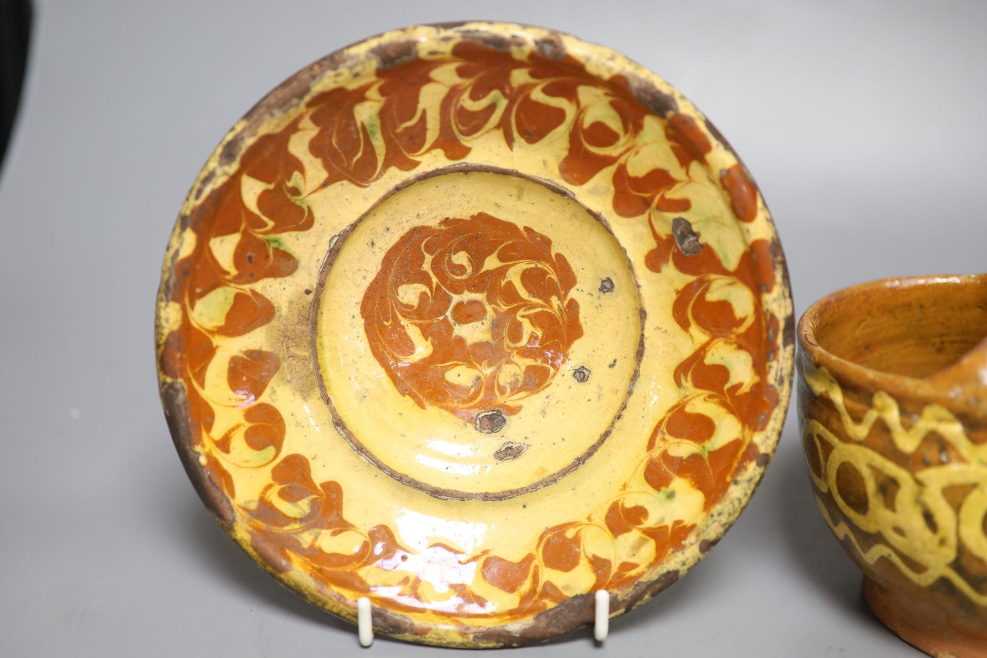 An early 19th century slipware basket, Donyatt Somerset and a similar slipware dish, diameter 18cm